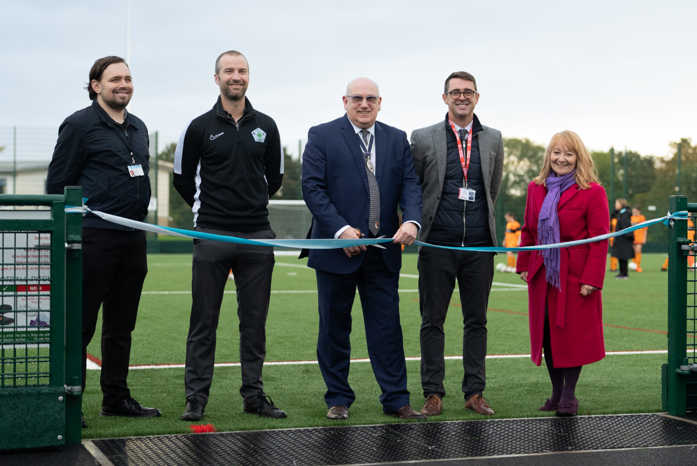 The official photo of Norfolk FA Chairman, Michael Banham, cutting a ribbon to open a new football pitch at Open Acacemy