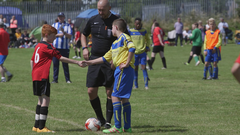 Two young players shake hands ahead of a game in the Sheffield & District Junior Football League