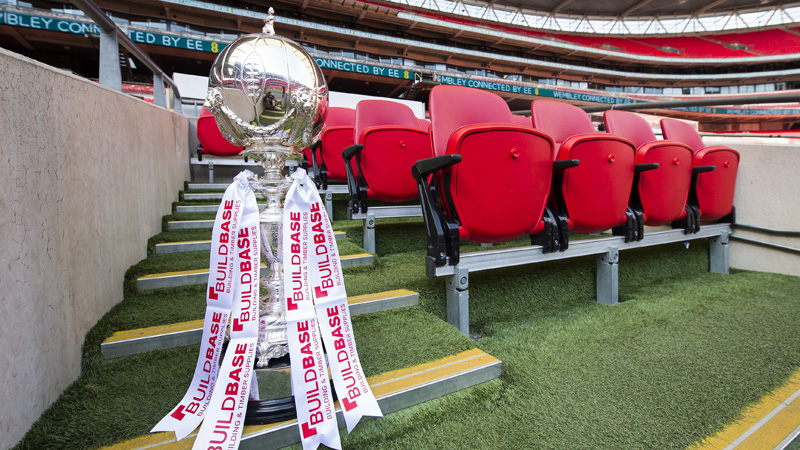 The Buildbase FA Trophy sits on the bench at Wembley Stadium
