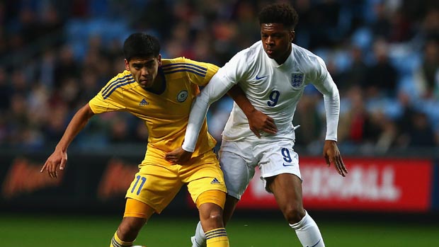 England striker Chuba Akpom tussles with a Kazakhstan defender.
