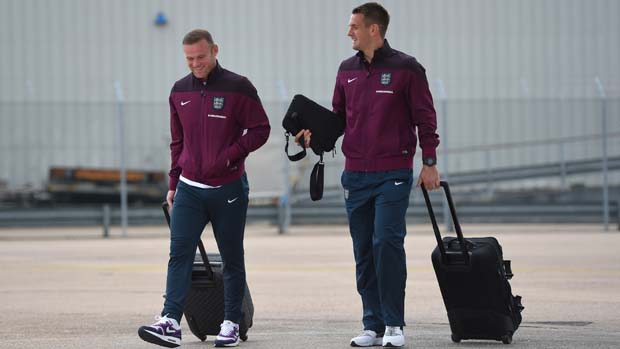 Captain Wayne Rooney and Tom Heaton prepare to board the England plane