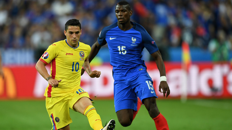 Nicolae Stanciu of Romania and Paul Pogba of France compete for the ball 