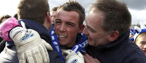 Glossop North End goalkeeper, Ashlea Gotham (centre) is congratulated by his manager Steve Young.