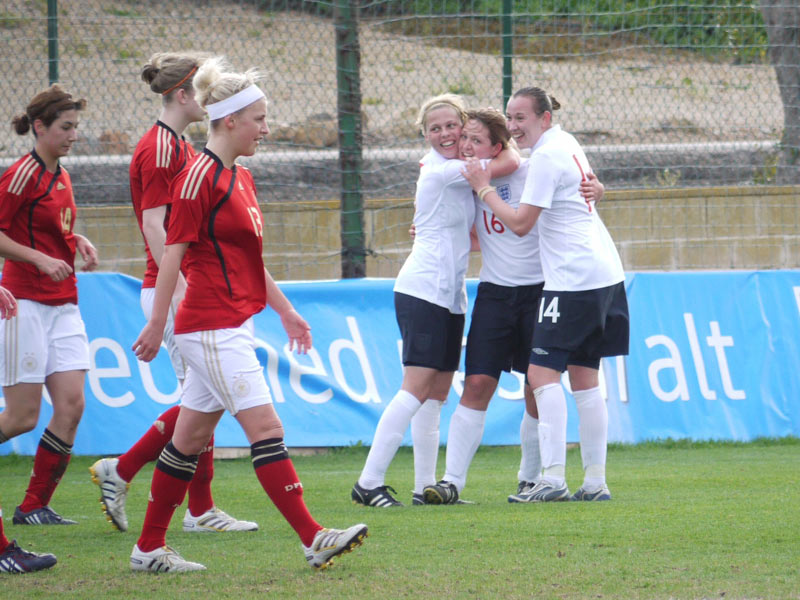 Jodie Jacobs (no. 16) is congratulated by Gilly Flaherty (left) and Jessica Holbrook after scoring the third goal against Germany.