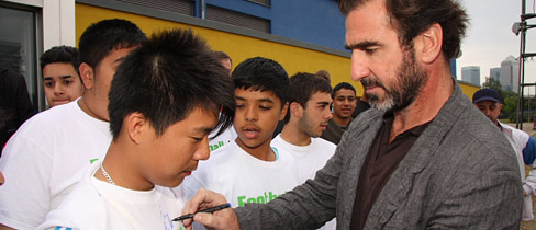 Cantona takes some time out to sign a few autographs.