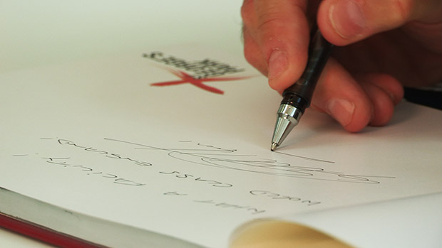 Sir Goeff Hurst signs his name at St. George's Park