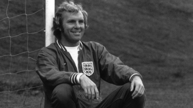 Bobby Moore leans against goalpost durring training for England