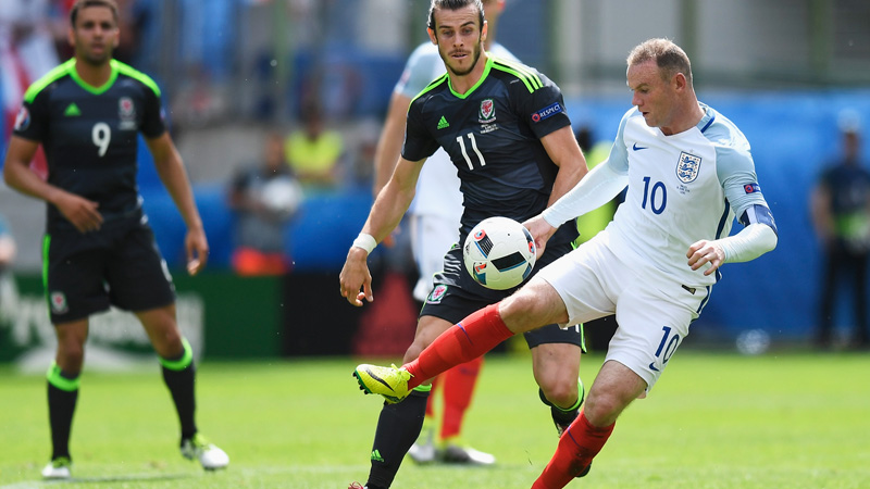 England captain Wayne Rooney controls the ball under pressure from Gareth Bale.